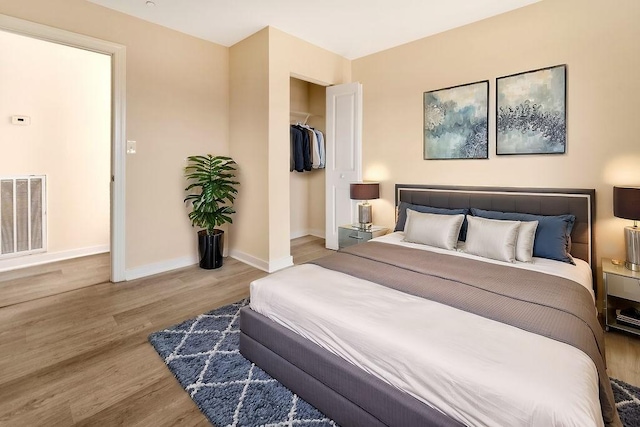 bedroom with a walk in closet, a closet, and light wood-type flooring