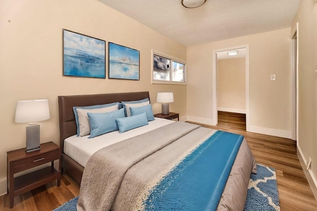 bedroom featuring hardwood / wood-style flooring and a textured ceiling