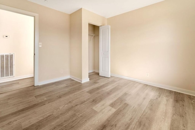 unfurnished bedroom featuring a closet and light hardwood / wood-style flooring