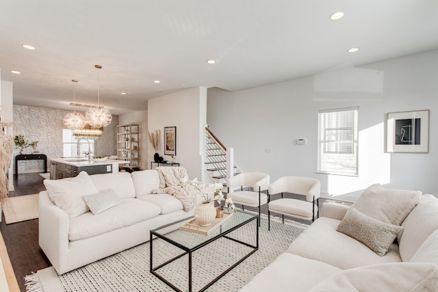 living room with hardwood / wood-style flooring, sink, and a chandelier