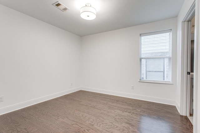 spare room with dark wood-type flooring