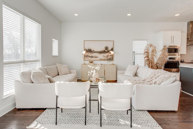 living room featuring a wealth of natural light and dark wood-type flooring