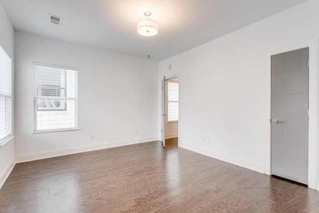 empty room with dark hardwood / wood-style flooring