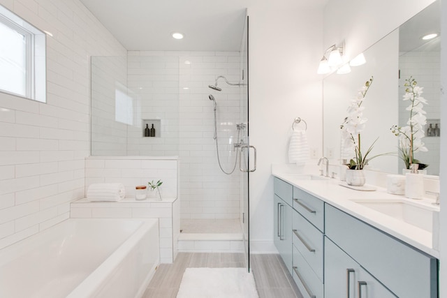 bathroom featuring vanity and independent shower and bath