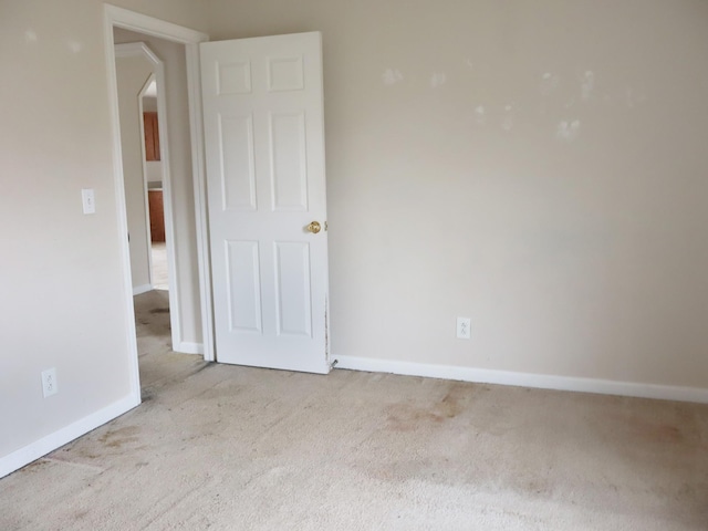 unfurnished room featuring light colored carpet