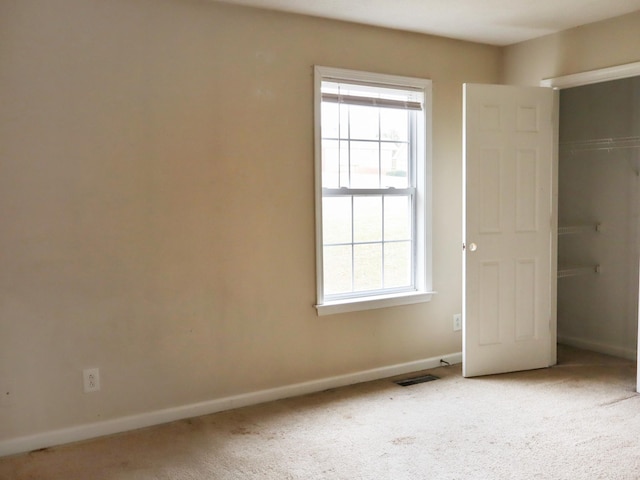 unfurnished bedroom featuring carpet flooring and multiple windows