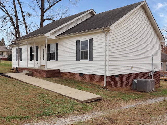 view of front of house featuring cooling unit, covered porch, and a front lawn