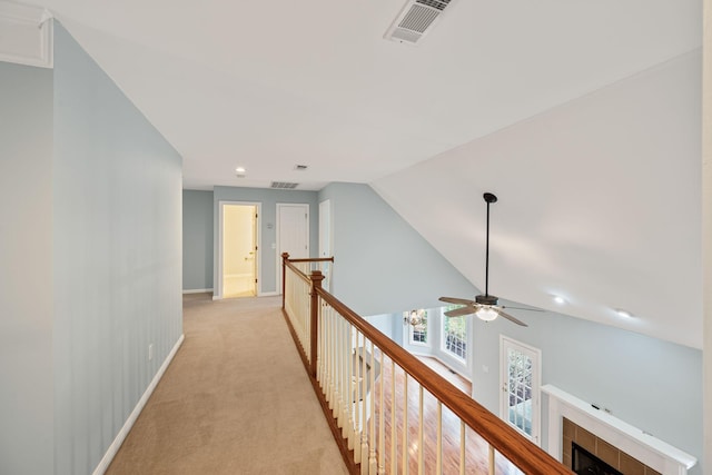 hall featuring light colored carpet and vaulted ceiling