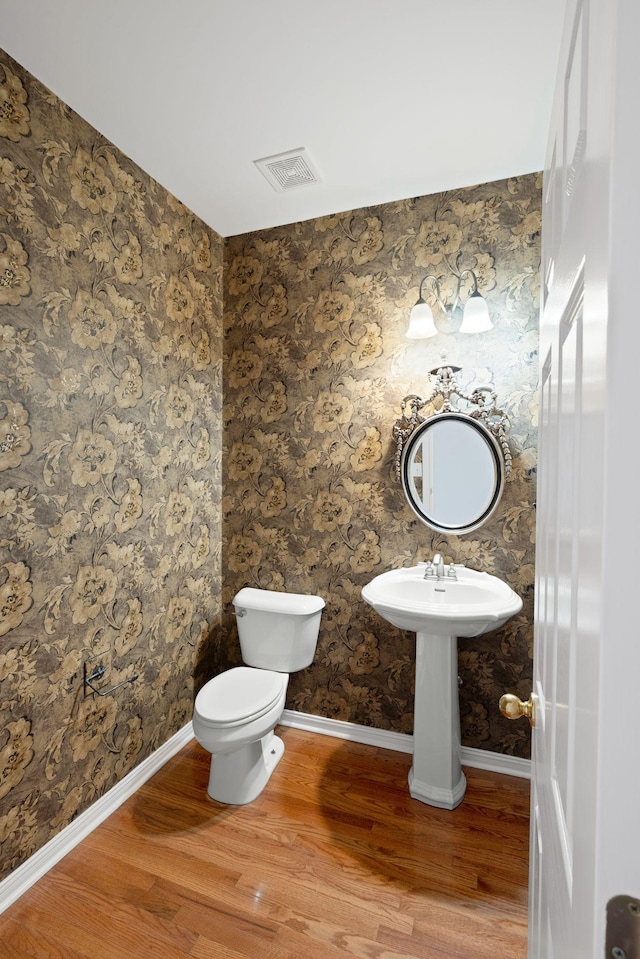 bathroom with hardwood / wood-style floors and toilet