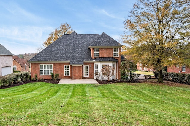 rear view of property with a yard and a patio