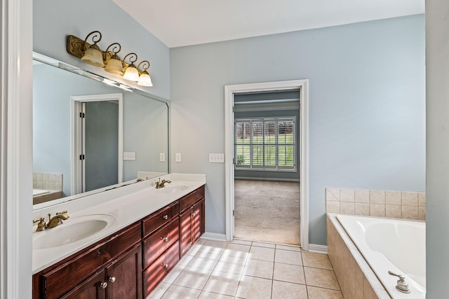 bathroom featuring tile patterned flooring, vanity, and tiled tub