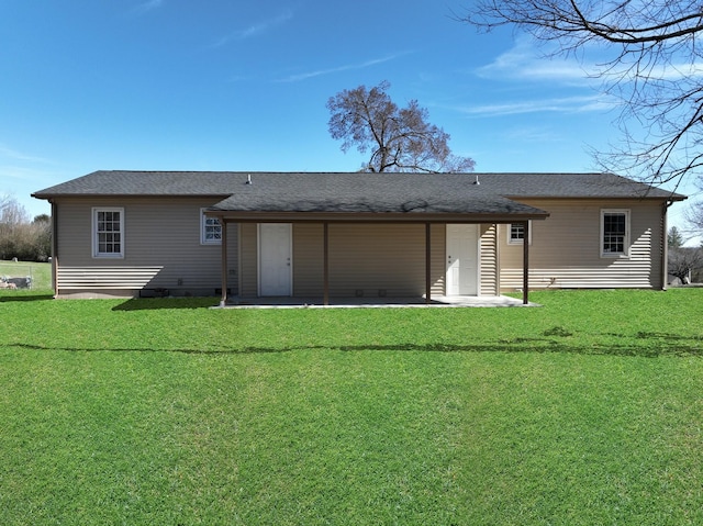 rear view of house featuring a patio area, roof with shingles, and a yard