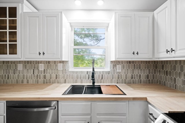 kitchen featuring white cabinets, decorative backsplash, stainless steel dishwasher, and sink