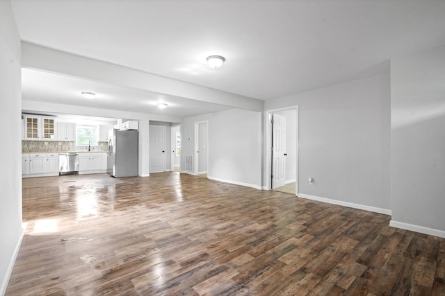 unfurnished living room featuring dark hardwood / wood-style flooring and sink