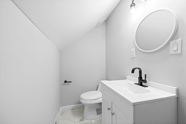 bathroom featuring vanity, toilet, and lofted ceiling