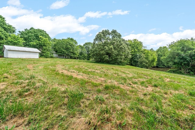 view of yard with an outbuilding and a rural view