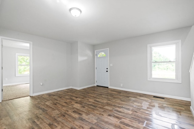 spare room featuring dark hardwood / wood-style floors and a healthy amount of sunlight