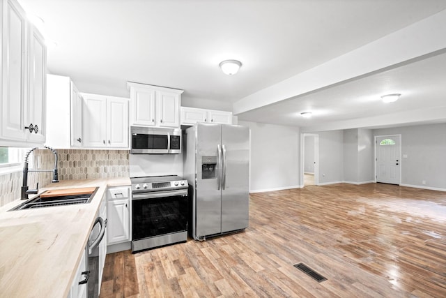 kitchen featuring light hardwood / wood-style floors, sink, white cabinetry, and stainless steel appliances