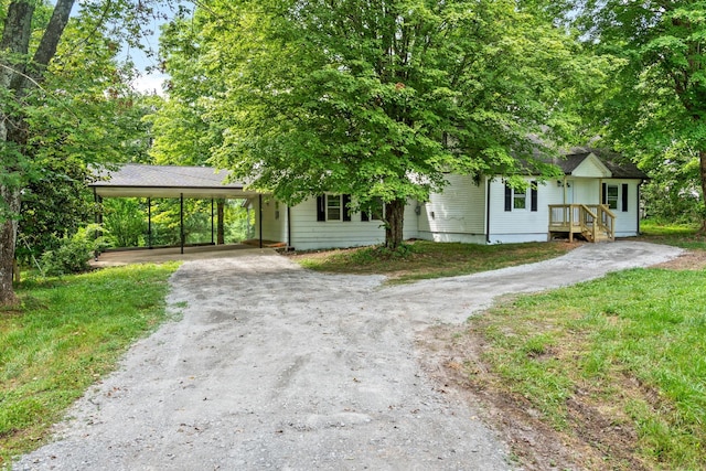 view of front of house with a front lawn and a carport