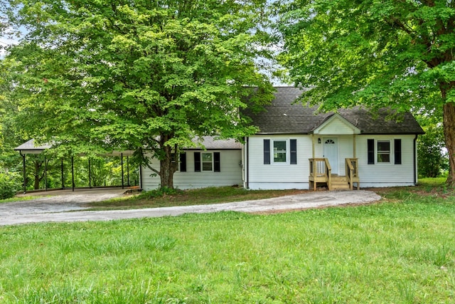 view of front of home with a front yard and a carport