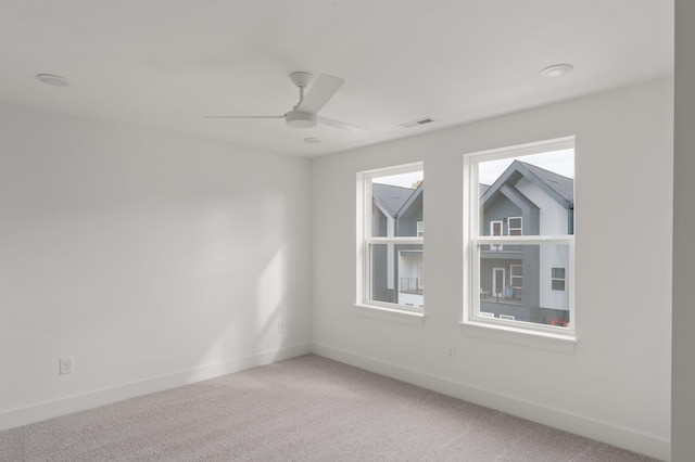 empty room with carpet, ceiling fan, and a wealth of natural light