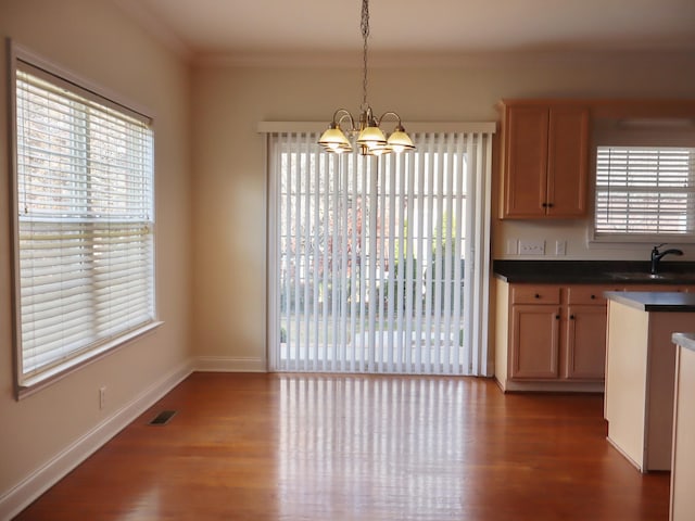 kitchen with dark hardwood / wood-style flooring, sink, decorative light fixtures, and a notable chandelier