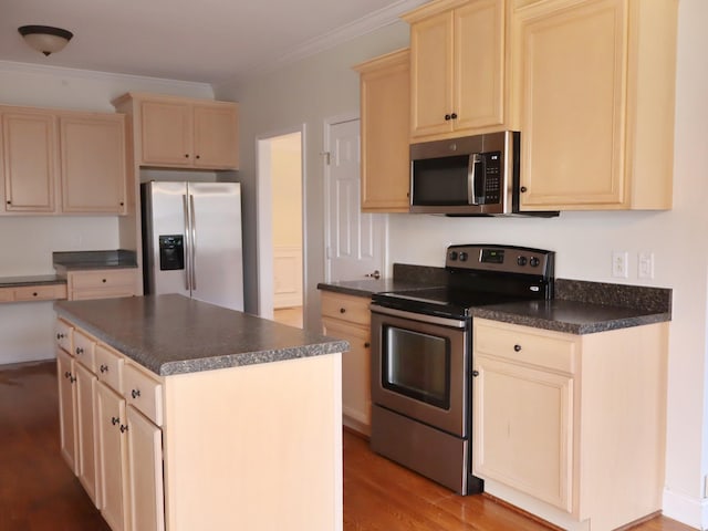 kitchen featuring appliances with stainless steel finishes, light wood-type flooring, a center island, and crown molding