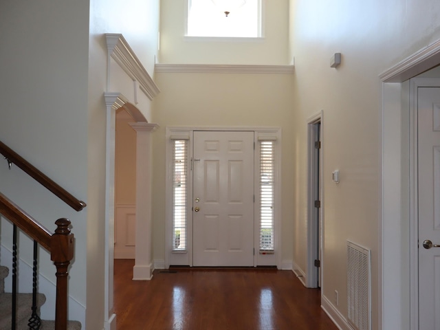 foyer entrance featuring dark hardwood / wood-style flooring and a high ceiling