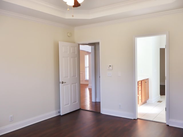 empty room with dark hardwood / wood-style flooring, ceiling fan, and ornamental molding