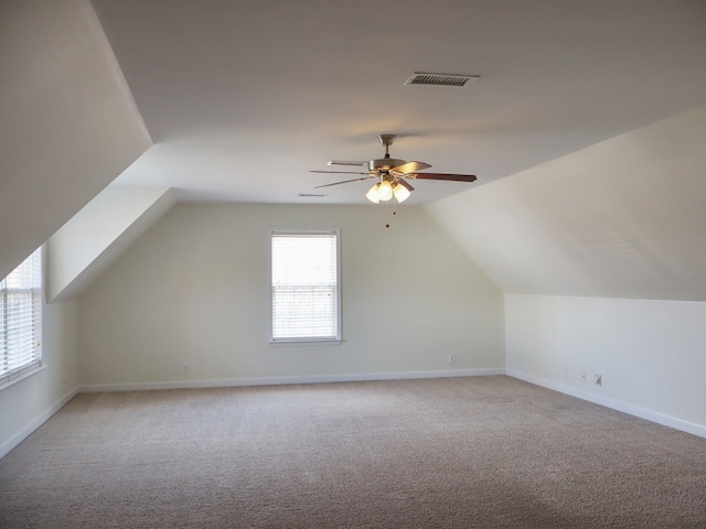 bonus room with plenty of natural light, lofted ceiling, and light carpet