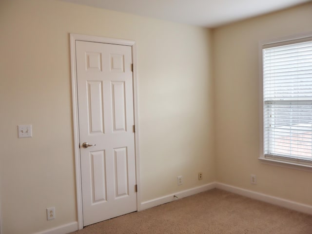 spare room with light colored carpet and a wealth of natural light