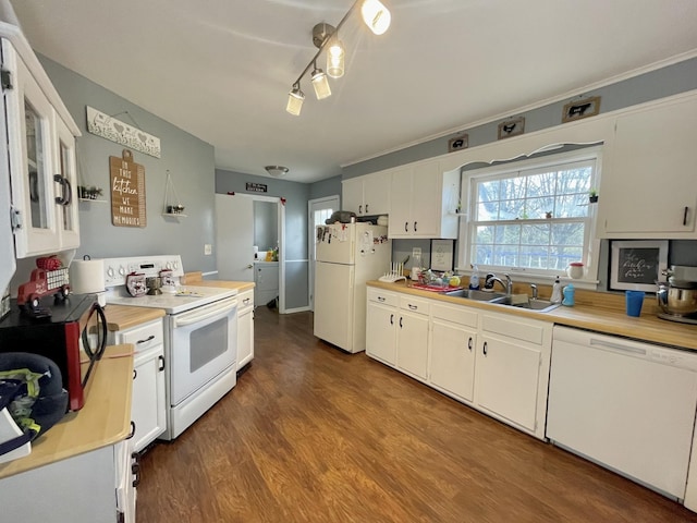 kitchen with white cabinetry, sink, hardwood / wood-style floors, white appliances, and washer / dryer