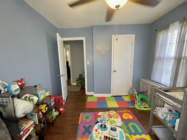 recreation room featuring ceiling fan and dark hardwood / wood-style flooring