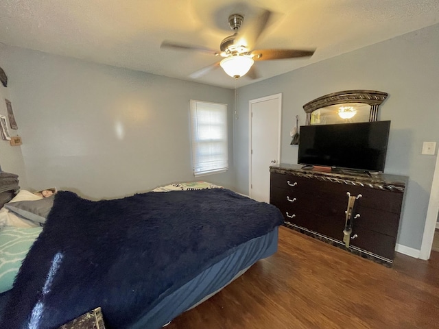 bedroom with ceiling fan and dark wood-type flooring