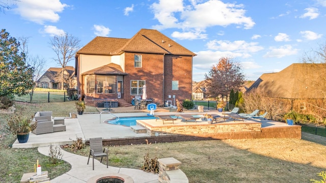 back of house with a fenced in pool, an outdoor living space with a fire pit, a yard, and a patio