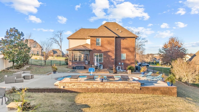 rear view of property with an outdoor living space, a lawn, and a patio