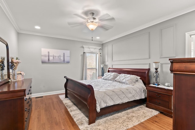 bedroom featuring ceiling fan, ornamental molding, and light hardwood / wood-style floors