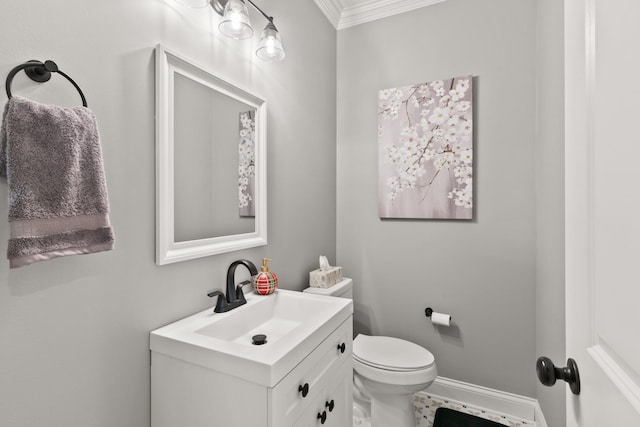 bathroom with toilet, vanity, and ornamental molding