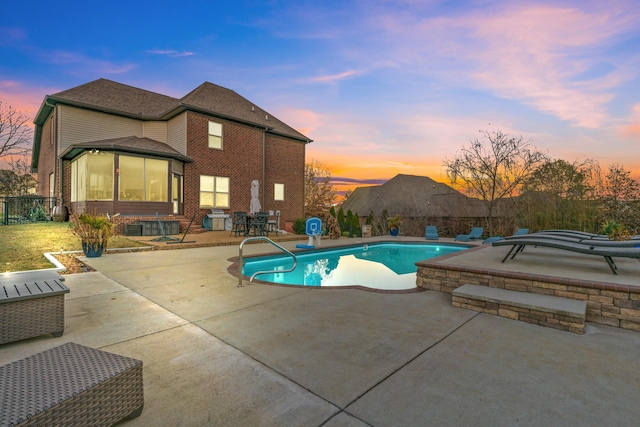 pool at dusk with a patio