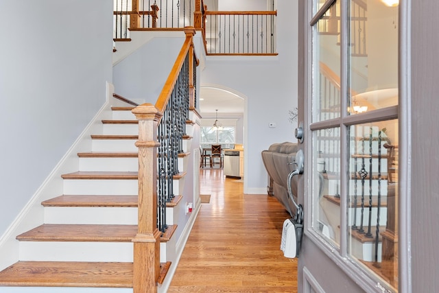 stairway featuring an inviting chandelier and hardwood / wood-style flooring