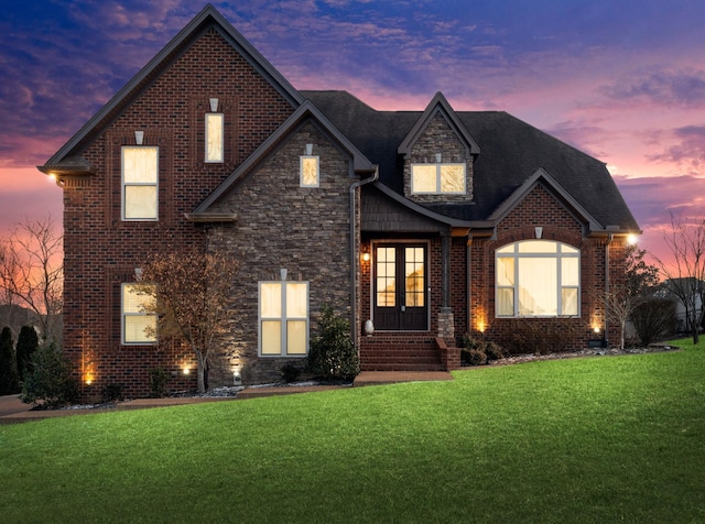 view of front facade with a lawn and french doors