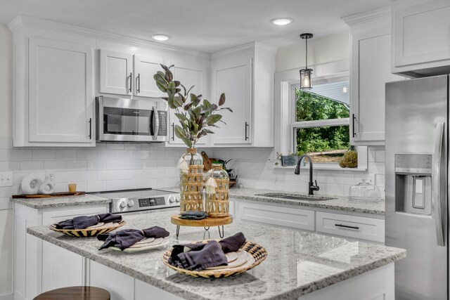 kitchen with white cabinets, decorative light fixtures, sink, and stainless steel appliances