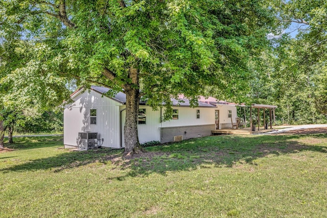 view of home's exterior with a yard, central AC unit, and a wooden deck