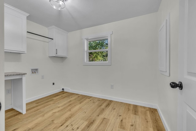 washroom with hookup for an electric dryer, cabinets, light wood-type flooring, and washer hookup