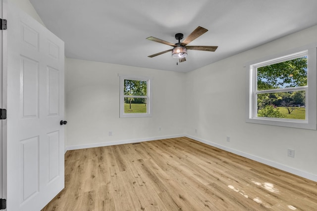 spare room featuring light hardwood / wood-style flooring, ceiling fan, and a healthy amount of sunlight