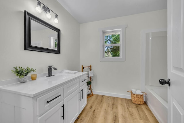 bathroom with vanity, hardwood / wood-style flooring, and shower / washtub combination