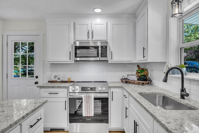 kitchen featuring a wealth of natural light, sink, white cabinets, and stainless steel appliances