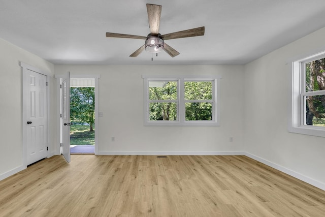 unfurnished room featuring a wealth of natural light, ceiling fan, and light hardwood / wood-style floors