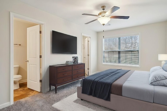 carpeted bedroom with ensuite bathroom and ceiling fan