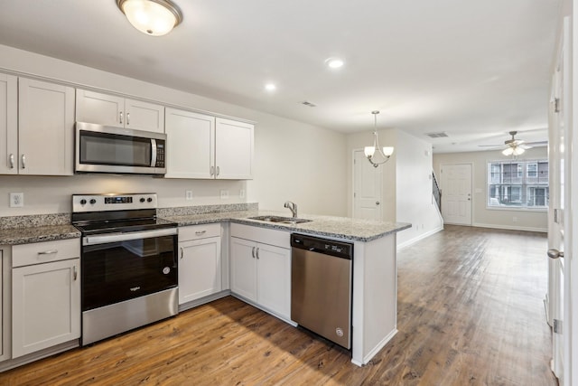 kitchen with kitchen peninsula, white cabinets, and stainless steel appliances